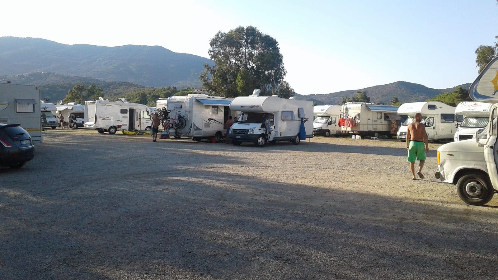 Il piazzale dell'area sosta con i camper in sosta e le colline sullo sfondo